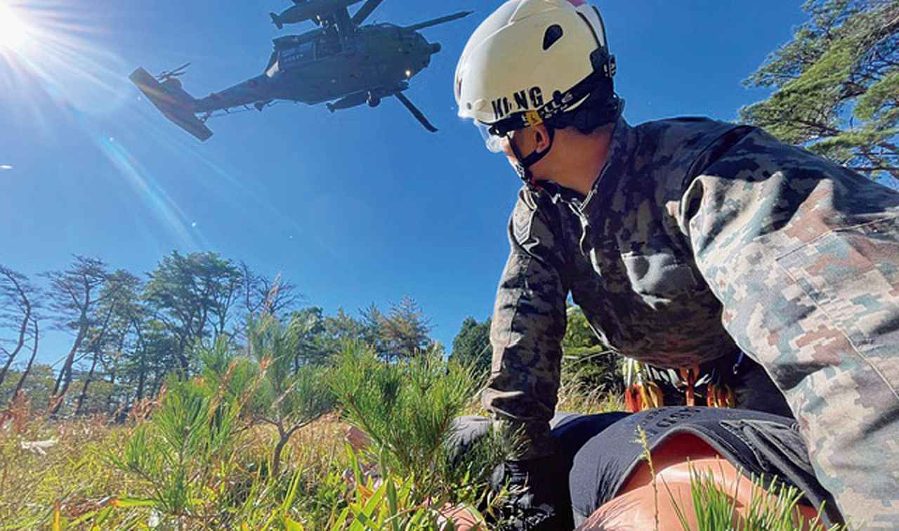画像: 取り残された要救助者救出のため山岳地にて救難活動を行う訓練。ヘリコプターの到着時間は決まっているため迅速で計画的な行動も求められる