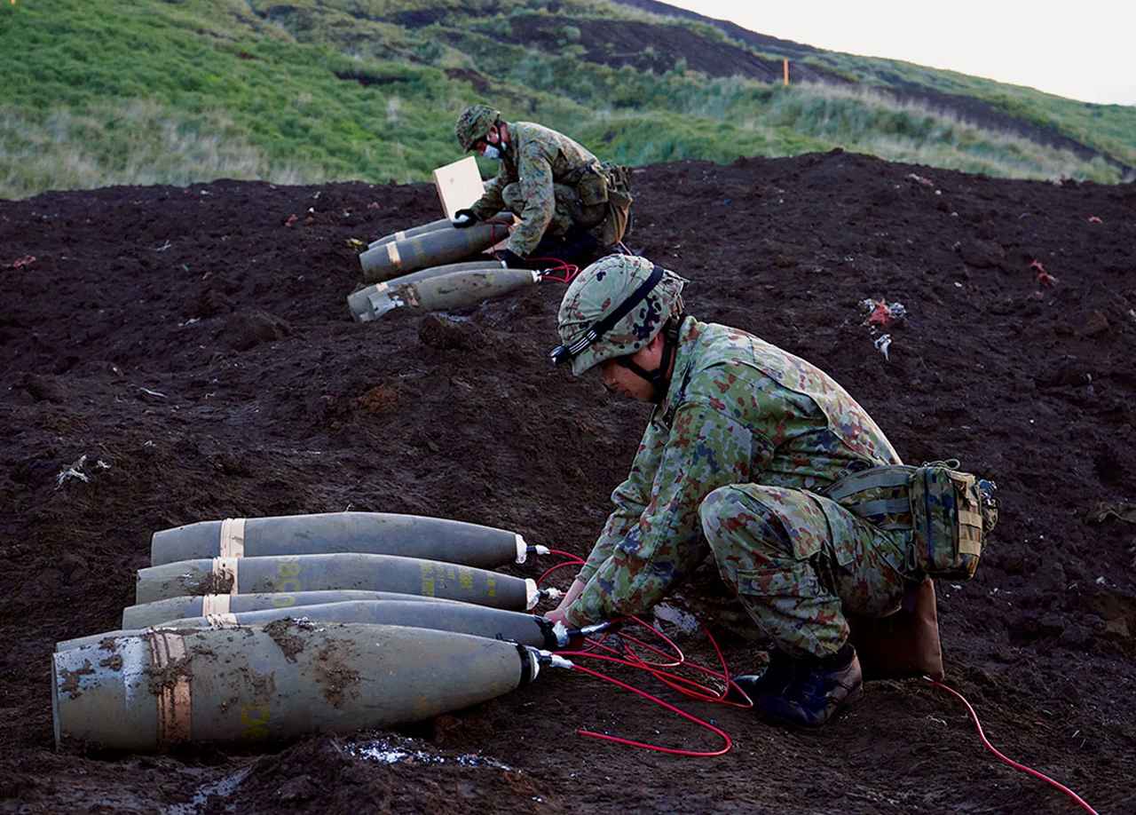 画像: 1発約90キログラムある砲弾を敵の侵攻が予測される場所に設置。起爆装置やコードを取り付け、リモートで爆破できるように爆薬をセットする隊員