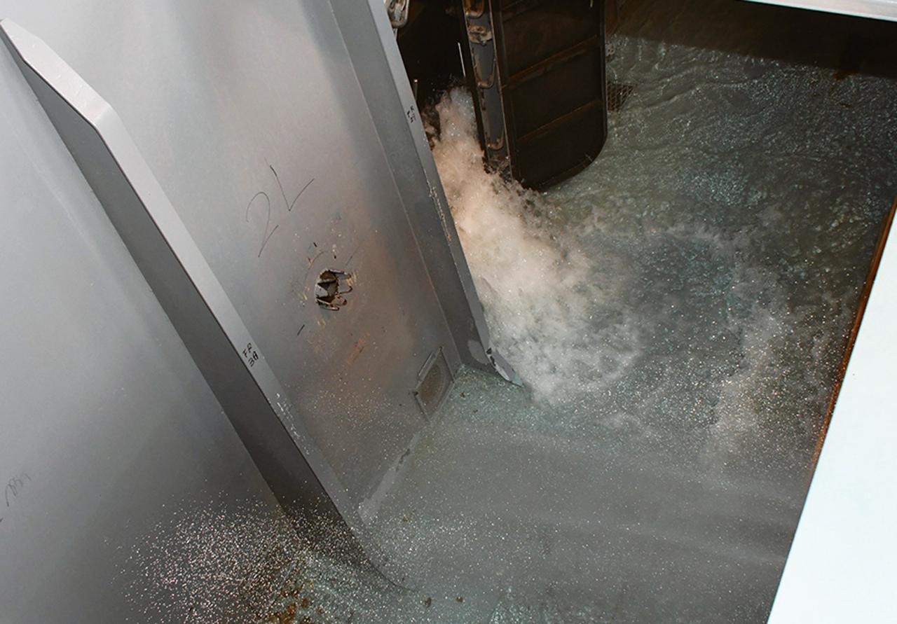 画像: 艦艇内を模した訓練場で浸水を再現。1カ所でも穴が開くと勢いよく海水が流れ込み一瞬にして沈没する恐れがある。復旧作業は1秒を争う