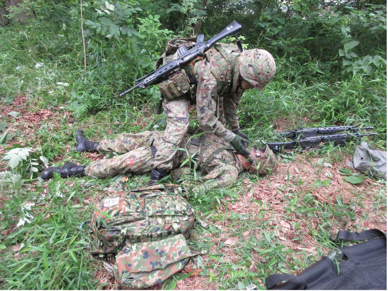 画像: 銃弾飛び交う最前線で負傷した隊員を搬送する訓練。生命維持のため出血部位に応じて1秒でも早く適切に止血する