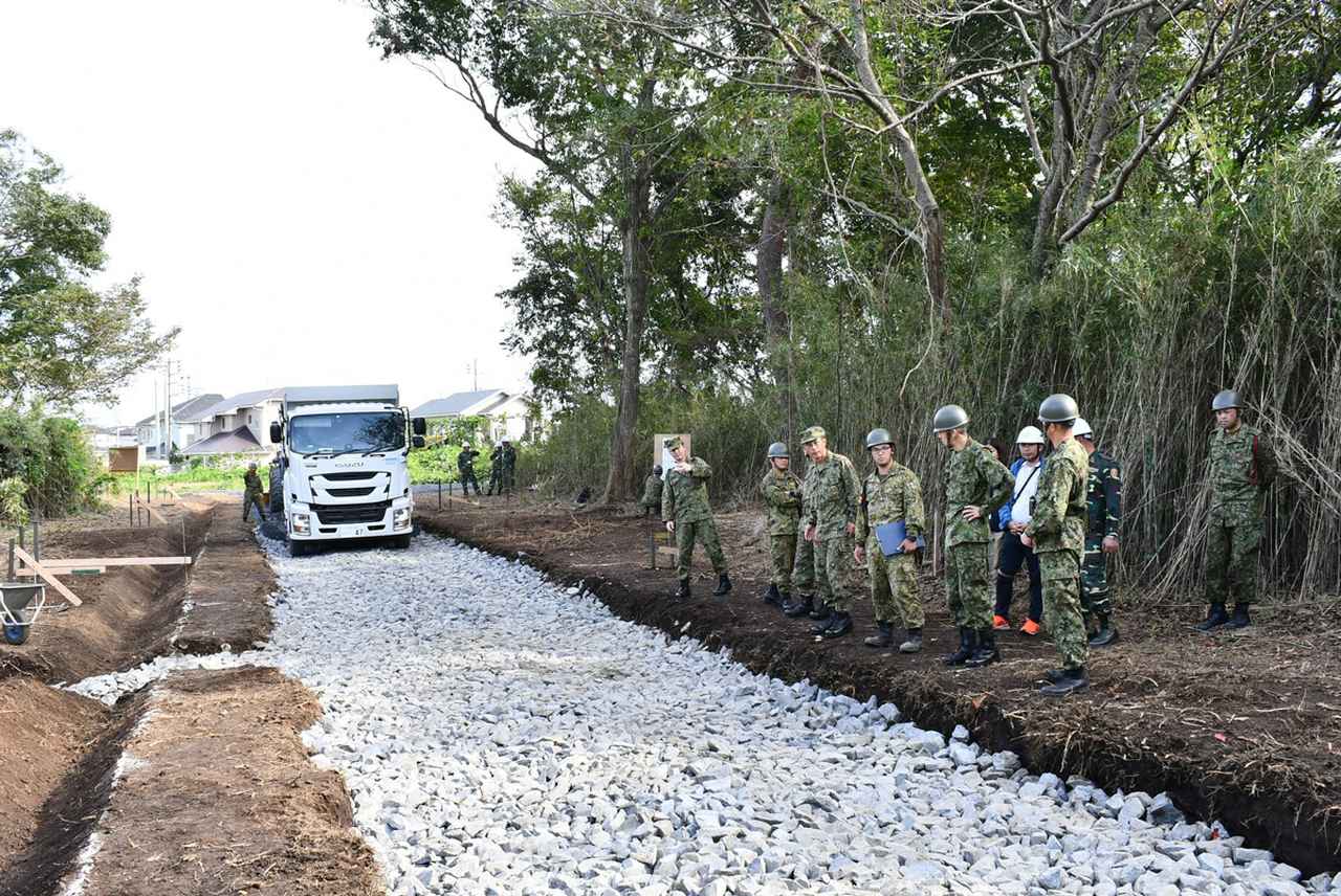 画像: ラオス人民軍に対して実施した道路整備の能力構築支援。作業の仕上げとして実際に車両を通し、安全かつ安定した道路が構築できたかを点検する
