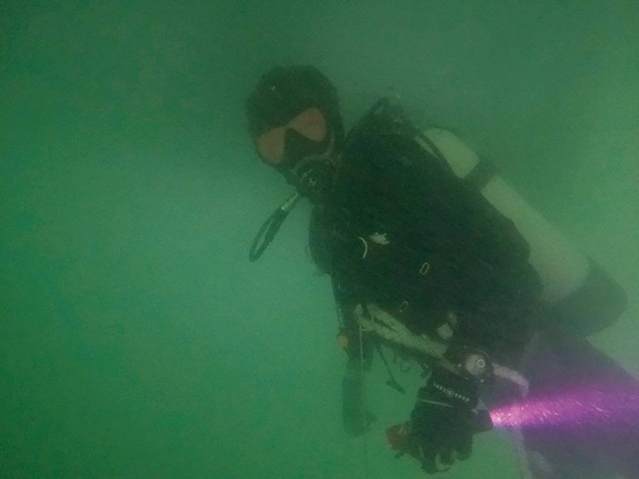 画像: 視界不良の海中で復旧作業を行う潜水士。作業時は海域の潮流や天候などの気象状況なども頭に入れながら短時間での復旧を目指す