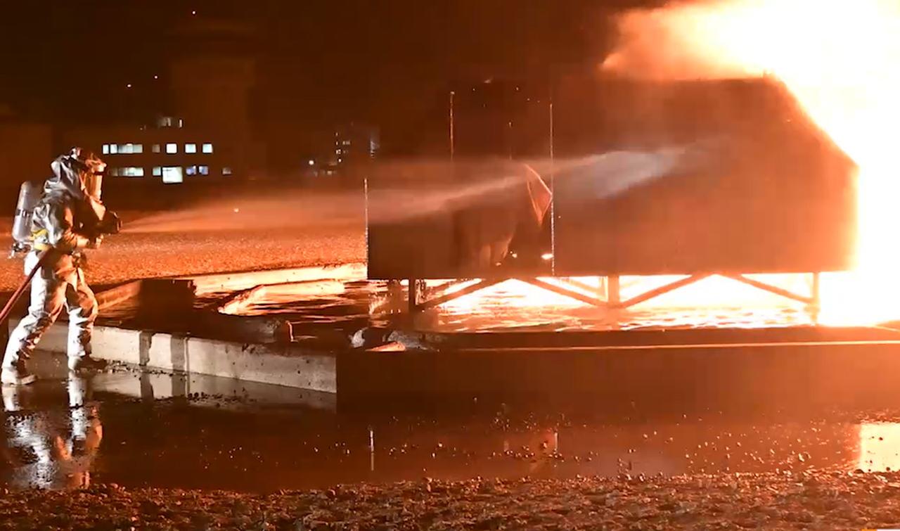 画像: 火点に向けて放水する隊員。消防車とともに連携して夜間の消火訓練に臨む