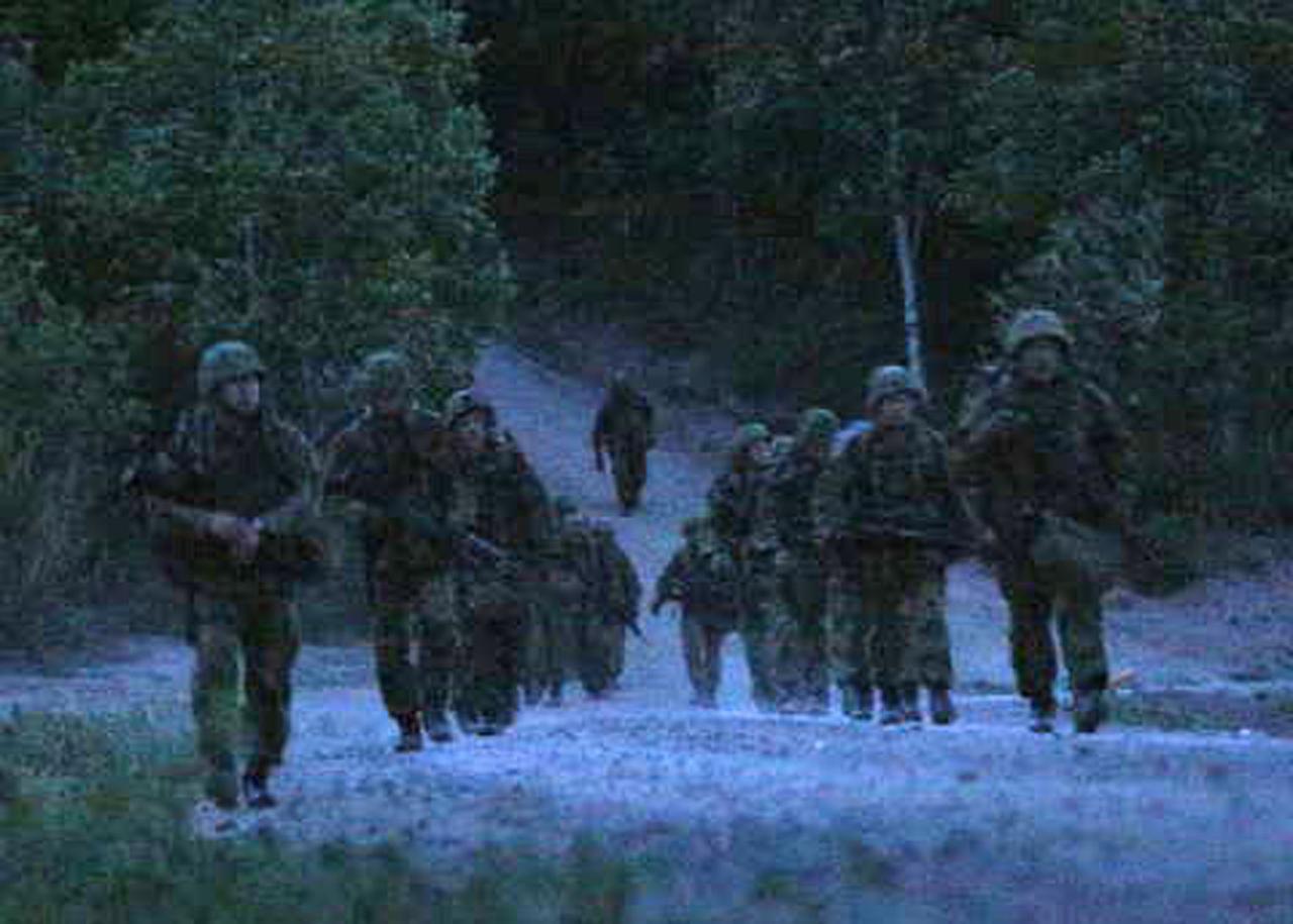 画像: 夜間行進を行う隊員ら。目的地まで数十キロメートルの距離を進んでいく。ほとんど周りが見えない状況でも隊列を崩さずに行進を進めなければならない。前後の隊員と歩調を合わせ、周囲を警戒しながら淡々と歩を進める