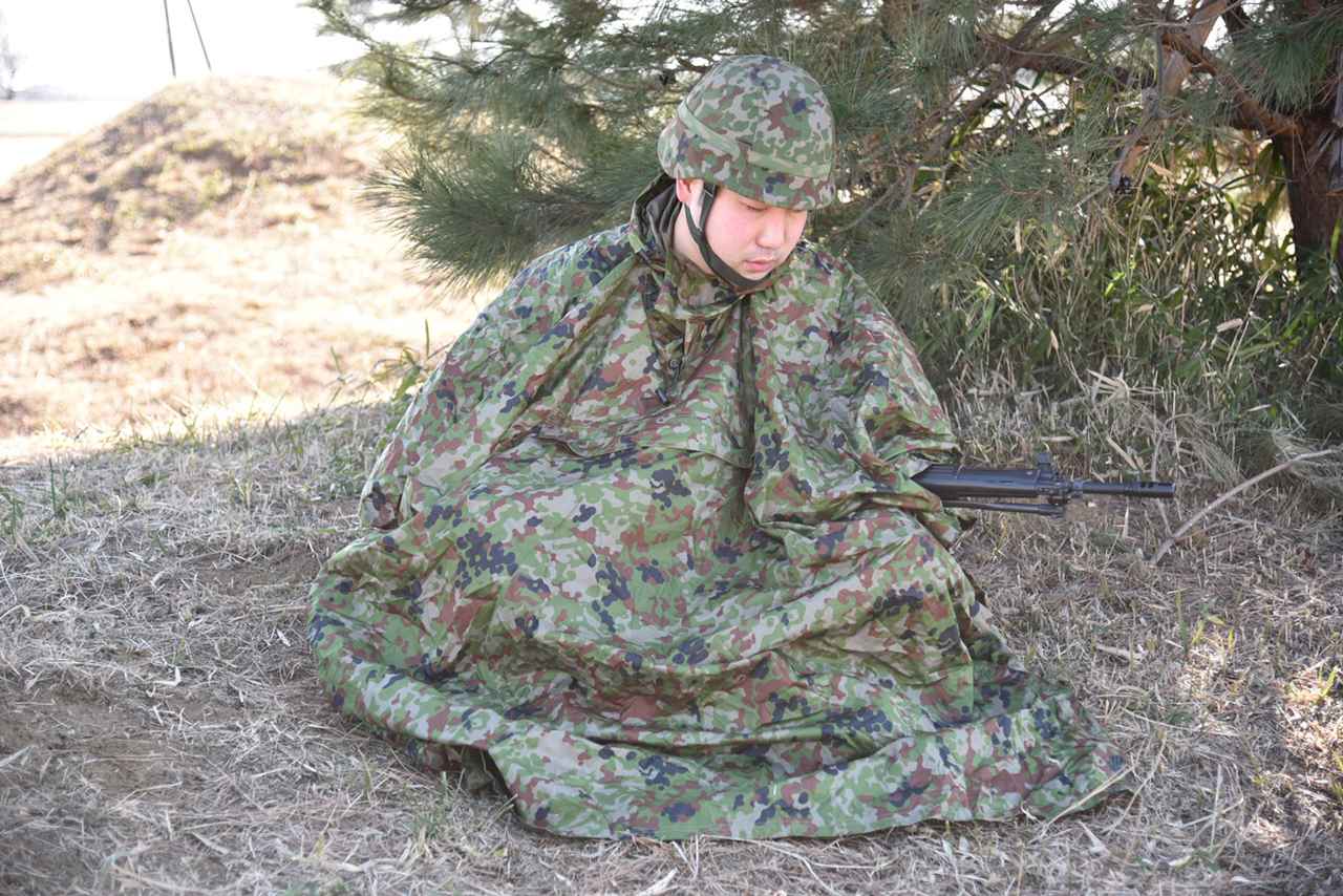 画像: ポンチョで擬装しながら仮眠をとる隊員