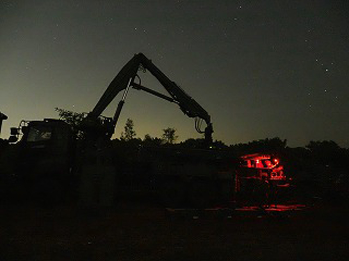 画像: 暗闇の中、重機を操作して掘削作業を行う隊員ら。明かりは最小限にしているため、非常に視界が悪いなかでの作業だ
