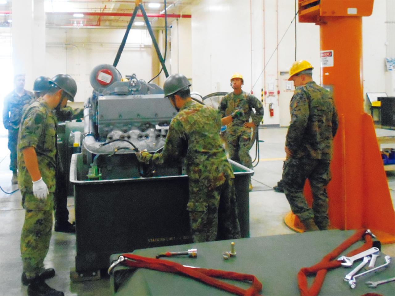 画像: アメリカ軍の隊員と車両エンジン整備の共同訓練を行う、目達原駐屯地（佐賀県）九州補給処の陸自隊員たち