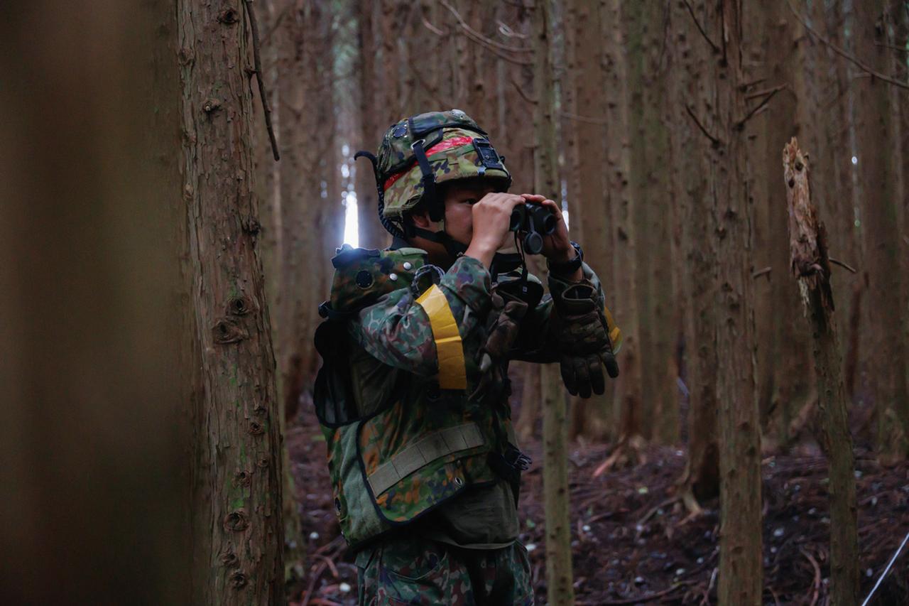 画像: ③警戒監視を24時間態勢で実施:陣地の近くにある、身を隠して敵に侵入されやすい森林内で、警戒監視を行う35普連の隊員