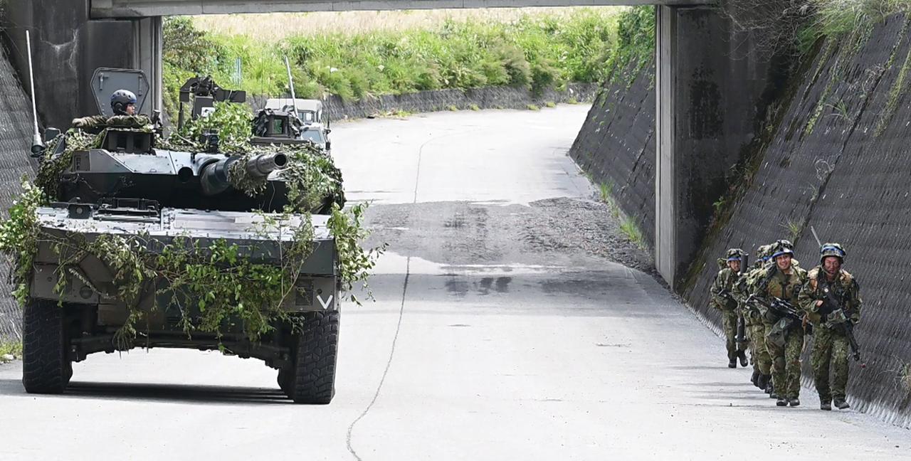 画像: ⑥前衛部隊に加わる主力部隊が前線へ移動：16式機動戦闘車とともに陣地付近へと移動する14普連の主力部隊。前線部隊の援護を受け、引き続き攻撃を行う　写真提供／防衛省