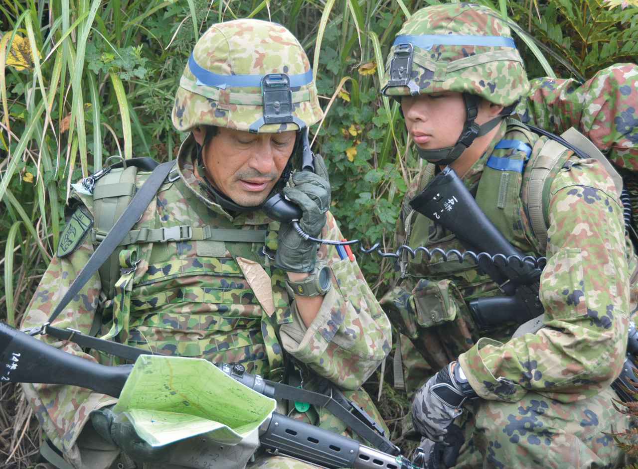 画像: ①攻撃に関する主要事項の調整を実施：攻撃を始める前に、チーム編成や攻撃のタイミング、侵入する方向などについて話し合う14普連の隊員たち　写真提供／防衛省