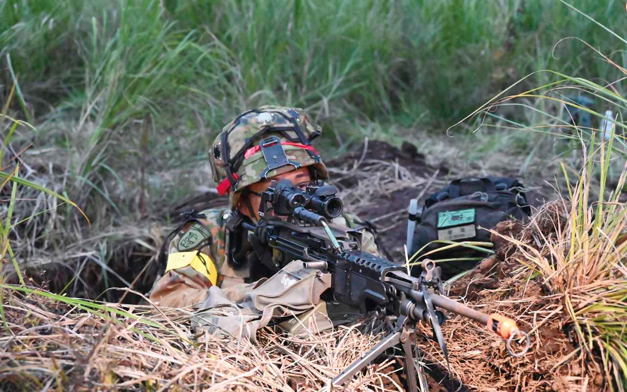 画像: ④35普連の隊員がえん体から機関銃で射撃：14普連からの攻撃に対し、えん体から5・56㎜機関銃で応戦する35普連の警戒部隊の隊員