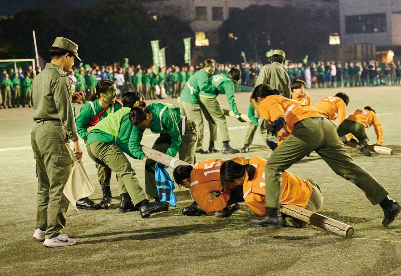 画像: 「棒引き」の決勝戦。棒を敵陣に運ばれまいと棒にしがみつき、一方、棒を自陣に運び込もうと力の限り棒を引っ張る女子学生たち