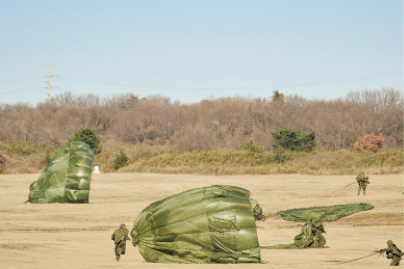 画像: 迅速に落下傘を収容し、作戦展開。戦闘行動に直ちに移行するため、落下傘で降下した隊員は素早く落下傘を収容する。畳んだ落下傘は作戦の状況に応じて持ち運ぶか、着地地点に置いて移動する