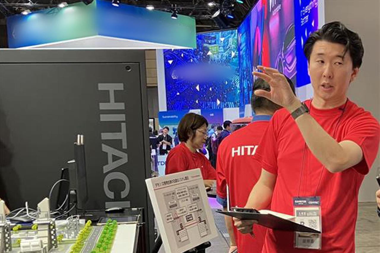 画像: 展示説明をする櫻井英暢（日立製作所 AI＆ソフトウェアサービスビジネスユニット データセンター事業本部）