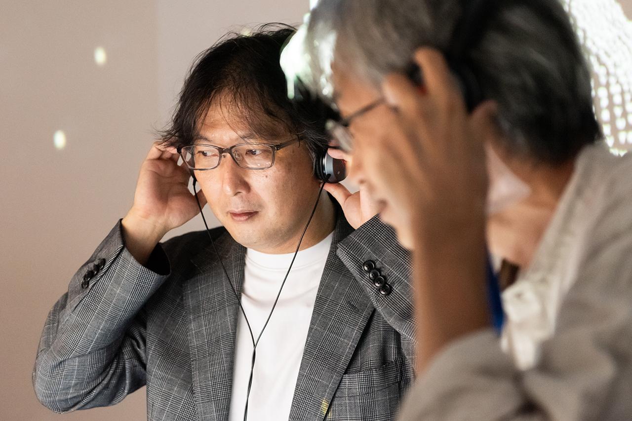 画像: 量子コンピュータ・ディスコのヘッドホンから流れてくる音楽に耳をすませる