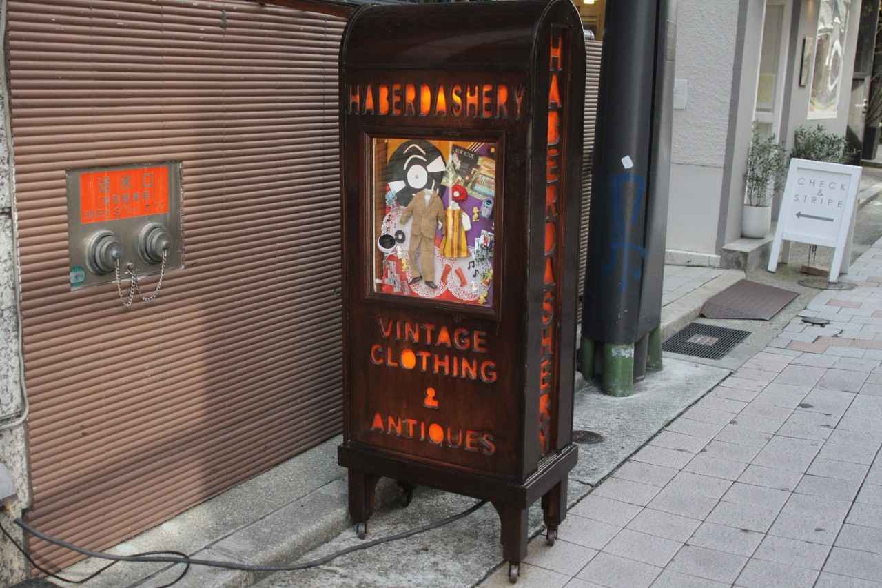 画像: ショーケースに手作りの洋服を着た人形が飾られている看板が目印