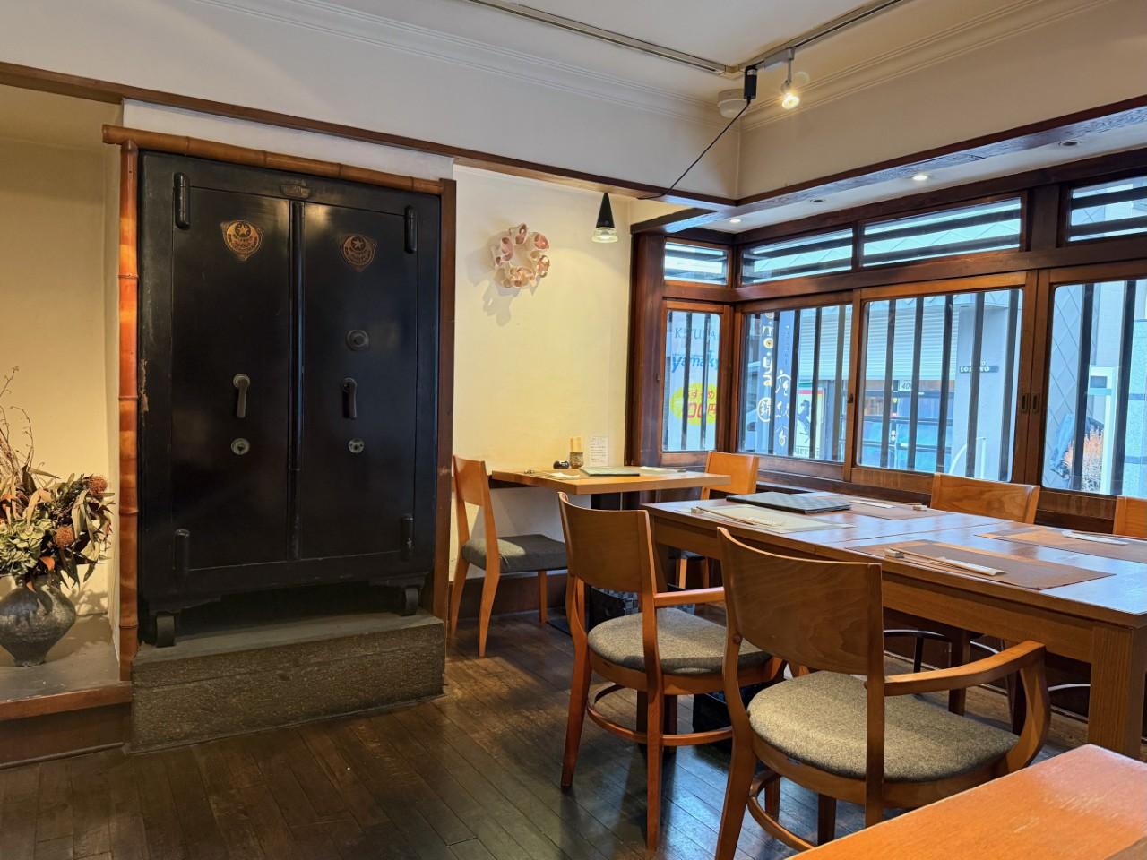 画像: 道路側のテーブル席。黒光りした扉は、なんと当時使われていた金庫だそう