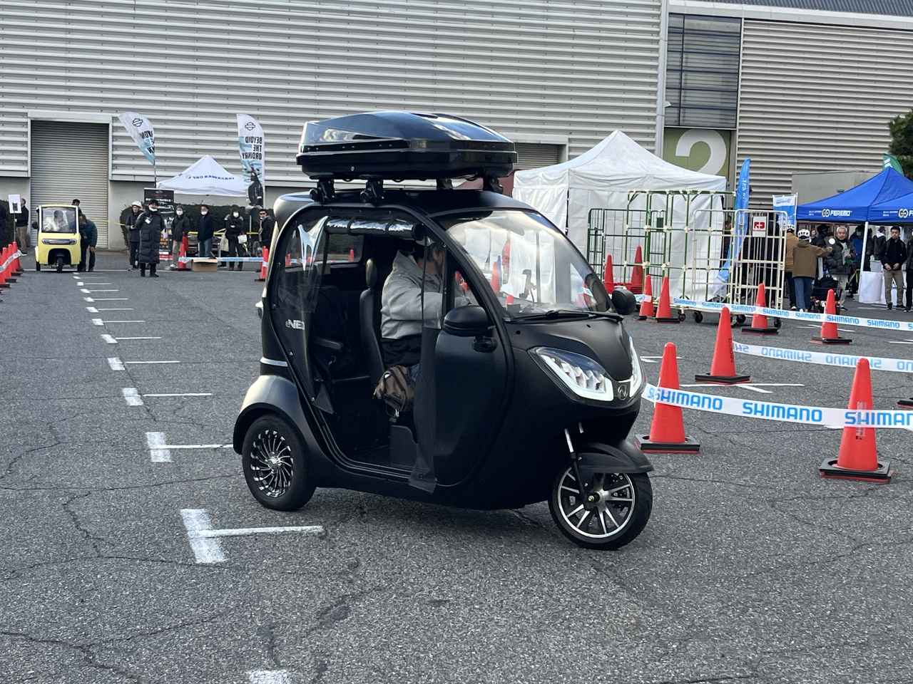 画像: 試乗コーナーを走行する「NEO-ONE（ネオワン）」。希望者は総合受付での手続き終了後、希望するモビリティのブースにて申し込みを行う事で試乗が可能となる。