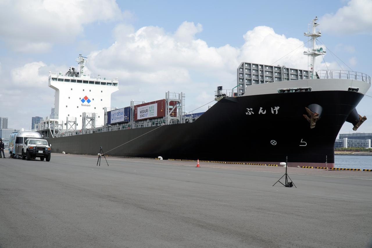 画像: 自動運航のコンテナ船「げんぶ」と左手前のトレーラーが陸上支援施設。
