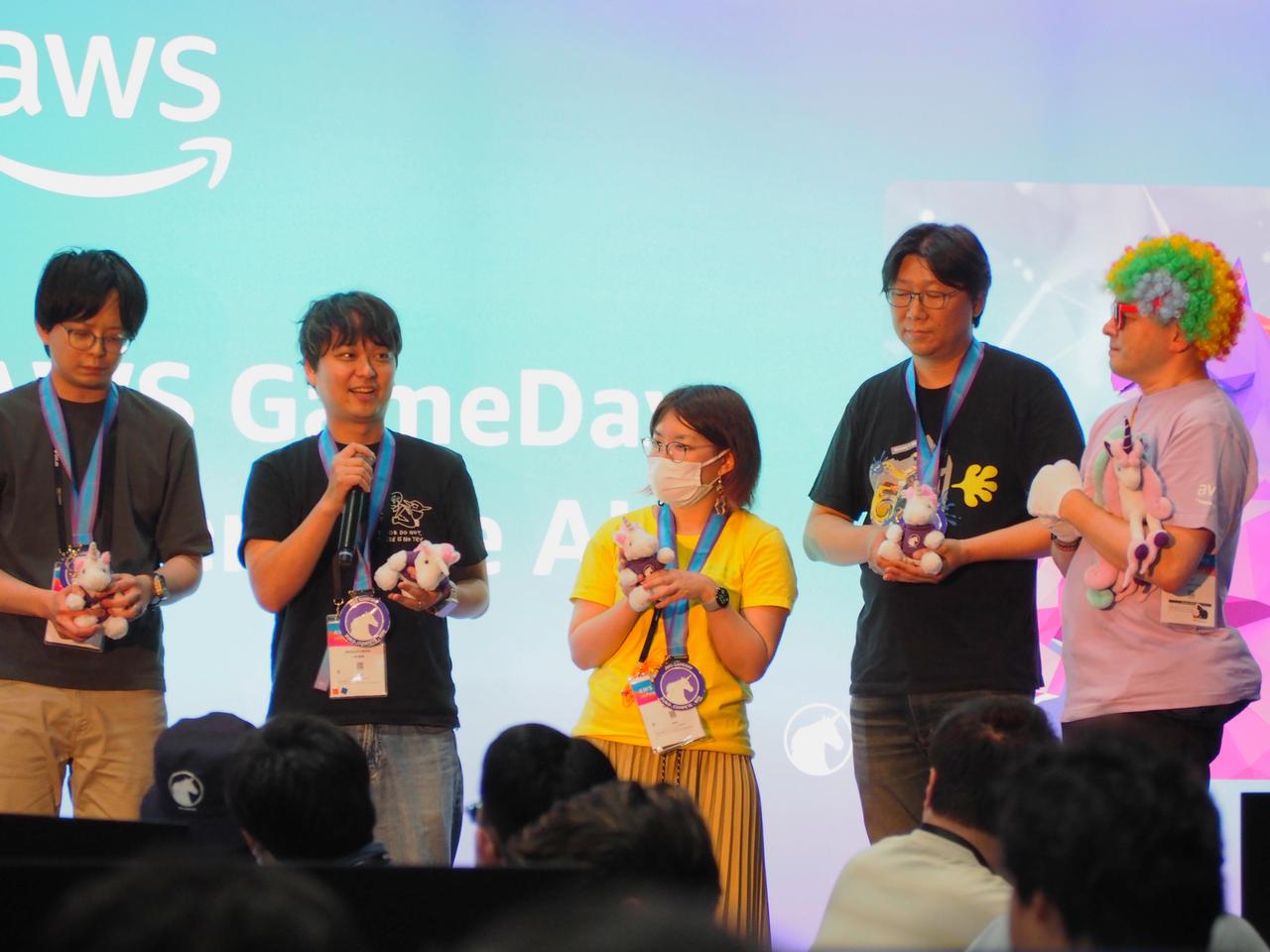 画像: みごと優勝を勝ち取った「Team ECS」 左から2番目、マイクを持つ日立の小林直樹さん。