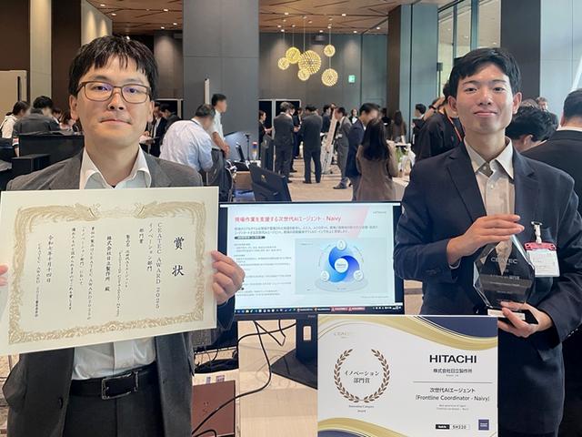 画像: CEATEC AWARD 2025発表 併設展示会場での様子 日立製作所 研究開発グループ 先端AIイノベーションセンタ 秋山 リーダー主任研究員、平川 研究員