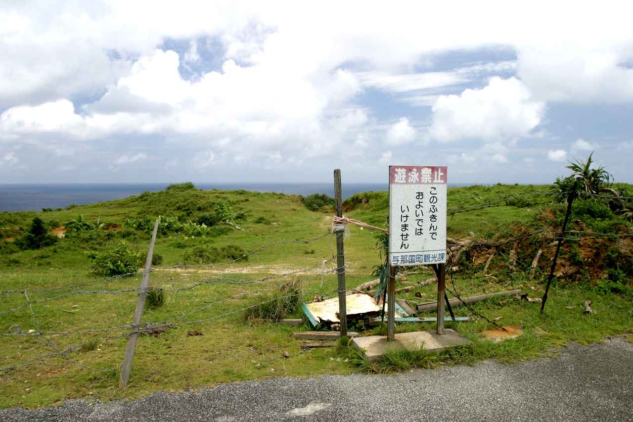 画像: 「ツア浜」浜に降りるには立て看板の先の牧場を通り過ぎていく。