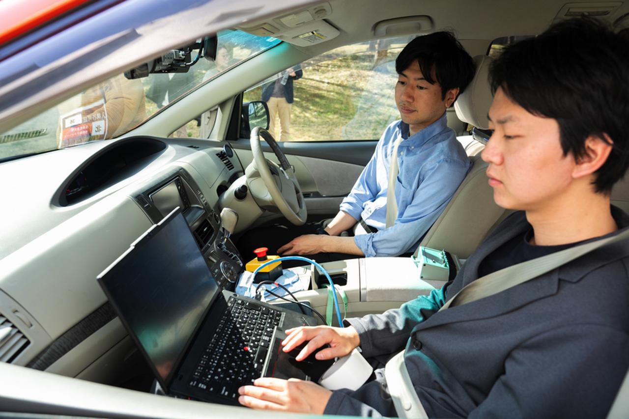 画像: Operation inside the vehicle during the trial. The high-accuracy sensors collect driving environment data and other detailed information.