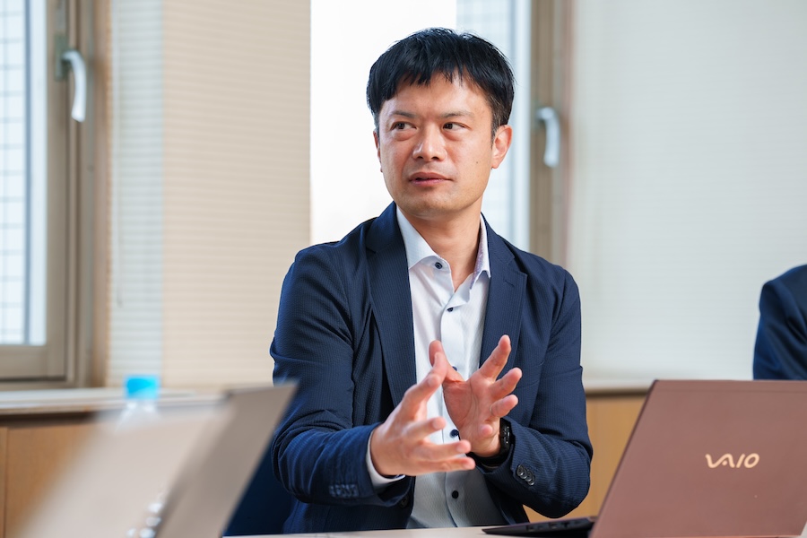 画像: Takehito Ogata talking about applying Hitachi’s expertise in control systems to autonomous driving technologies