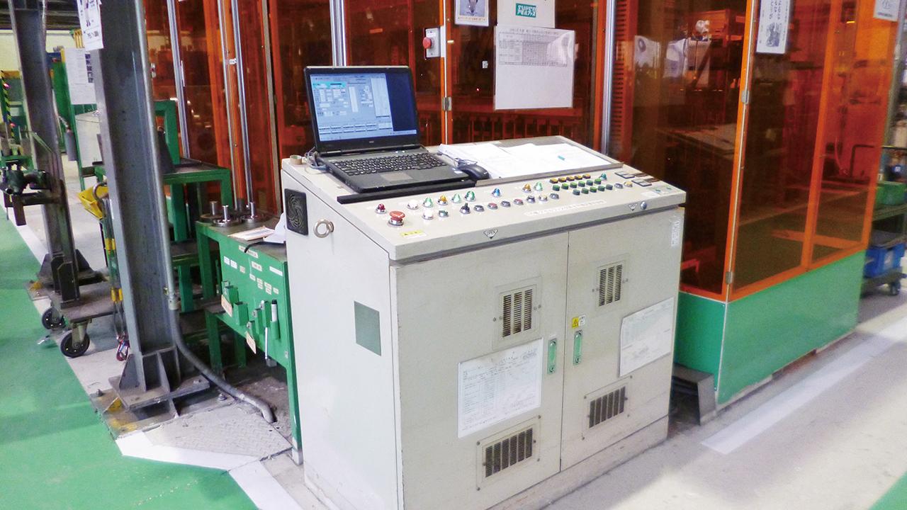 画像: 機械装置の前に設置された制御盤（PLC）