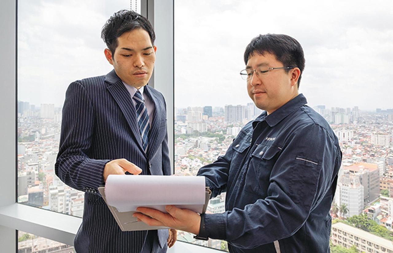 画像: 日立アジア（ベトナム）社のハノイ支店において 営業の森野郷志（左）とお客さま情報を確認