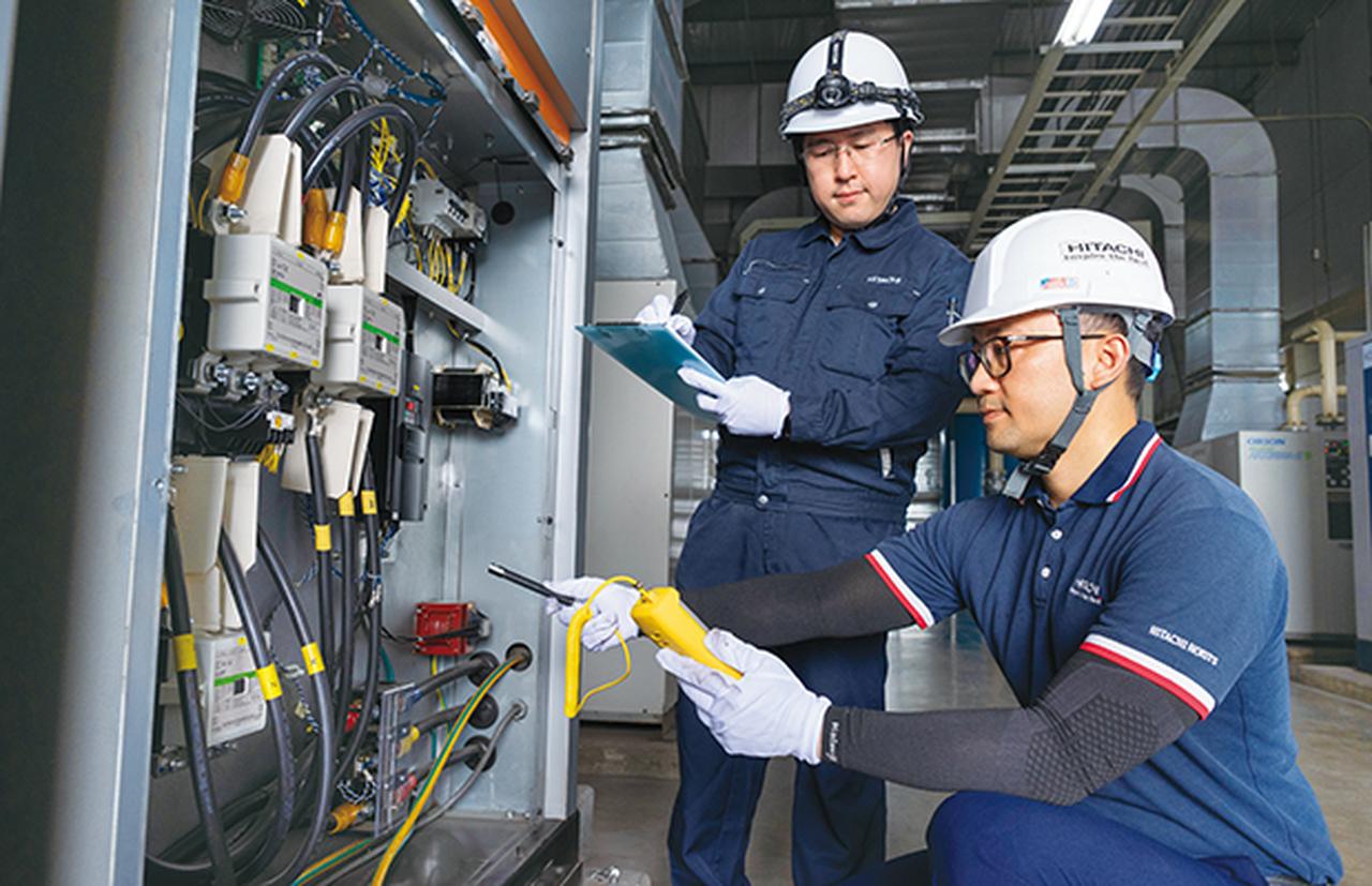 画像: 後輩のアン・ティエン・ルアット（右）とともに 日立給油式スクリュー圧縮機160kWを整備