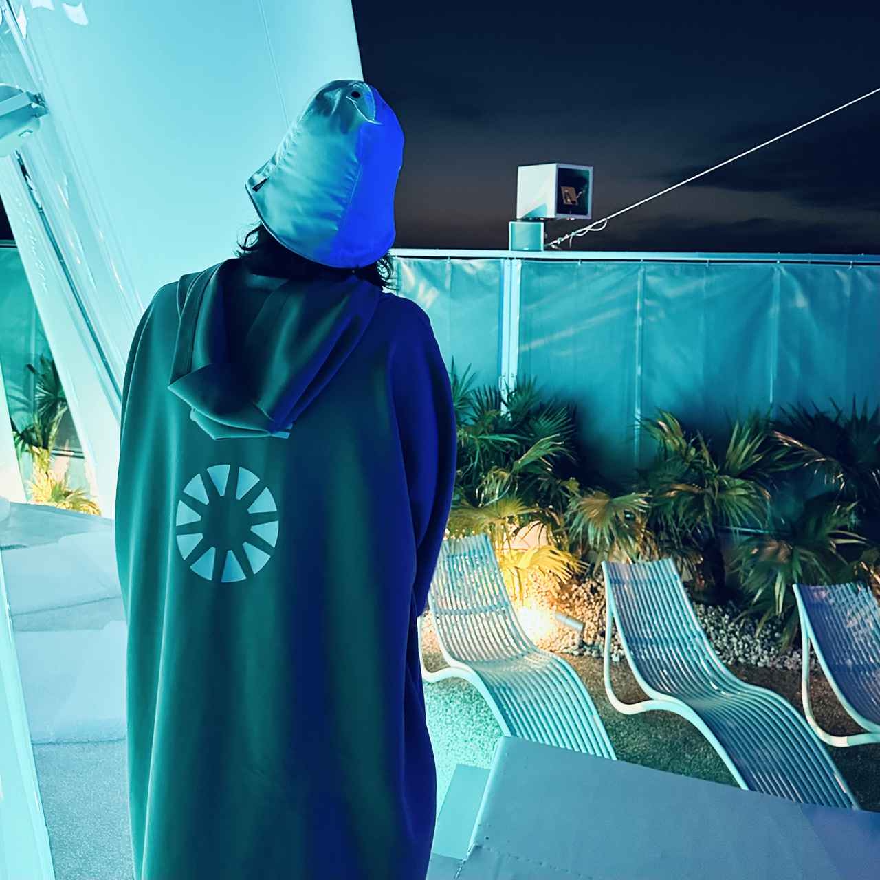 画像: 昼と夜でまったく異なる光の演出が楽しめる「太陽のつぼみ」。サウナテントをモチーフにしたロゴをバックプリントにあしらったサウナガイドのユニフォームは「SOPH.(ソフ)」とのコラボで、来場者も購入可能