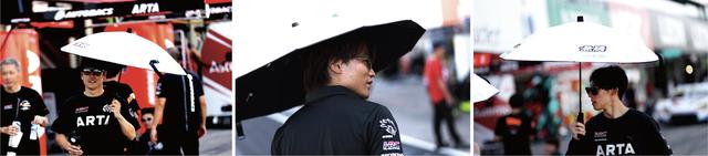 画像: 日傘を差してサーキット内を移動するドライバー達