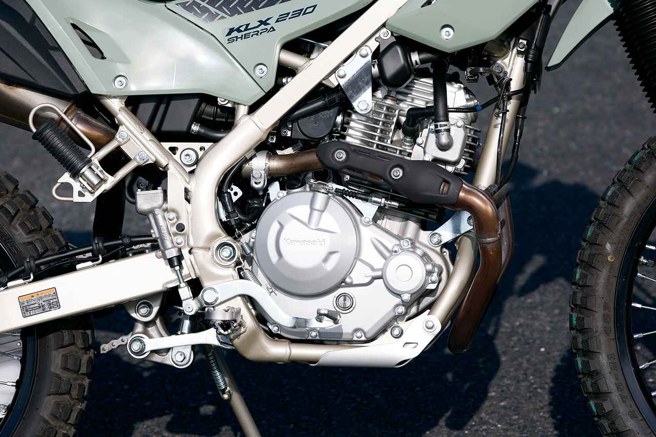 画像: エンジンはKLX230と共通の排気量232cc・空冷SOHC2バルブ単気筒エンジンを搭載しています。最高出力は18PS、粘り強いパワー特性でオフロード走行も充分に楽しめます。エンジンの下部に備えられたアルミスキッドプレートは標準装備品です。