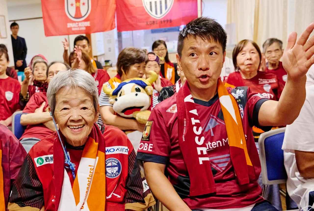 画像: 認知症を患い、今は介護施設で生活している80代の女性テルコさんと、生活する施設を訪れて声援を送る増田さん。「推し」選手の応援が生き甲斐になっているそうです。主催者提供