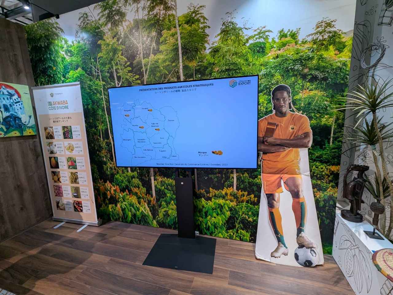 画像: コートジボワールパビリオンに展示されたドログバ選手のパネル。時に来場者を呼び込むスタッフが、ドログバ選手の名前を伝えたり、田中マルクス闘莉王氏とのエピソードを交えながら、国を紹介する姿も見られた。