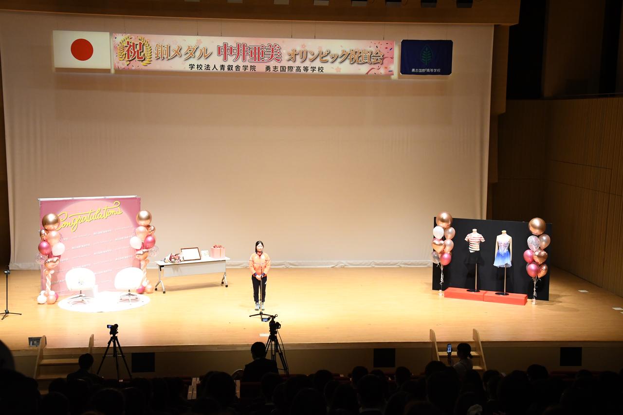画像: 在校生らが集うホールで挨拶をする中井選手