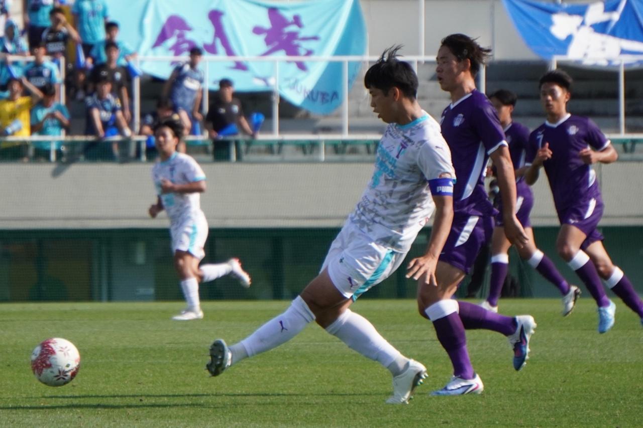 画像: 明治大の素早いプレッシャーの中、冷静にパスを散らす小川（写真　白谷遼）